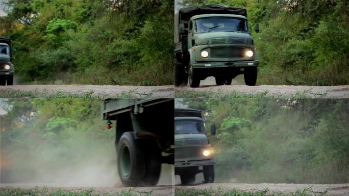 老旧的军用卡车在尘土飞扬的路上。低角度视图，4K分辨率。