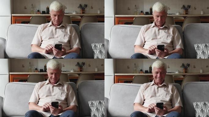 老年祖父坐在沙发上使用手机上的应用程序