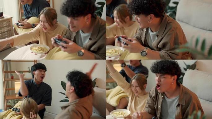 亚洲朋友在客厅坐在一起玩电子游戏。