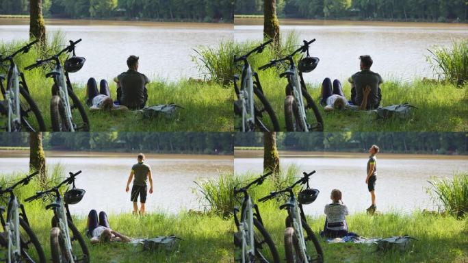 WS两个山地车手在湖边的草地上放松