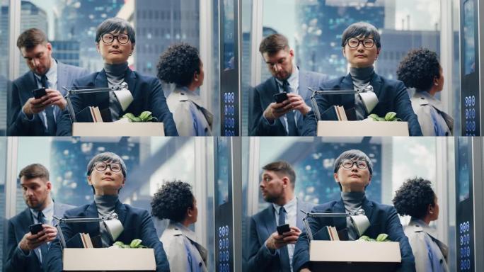 新员工第一天来到办公室，与现代商务中心的不同同事一起乘坐玻璃电梯。快乐的日本经理拿着带办公配件的纸箱