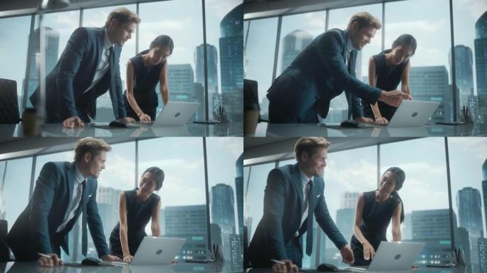 成功的公司首席执行官和投资经理的肖像，站在城市办公室时使用笔记本电脑交谈。两个商人用拳头庆祝成功的交