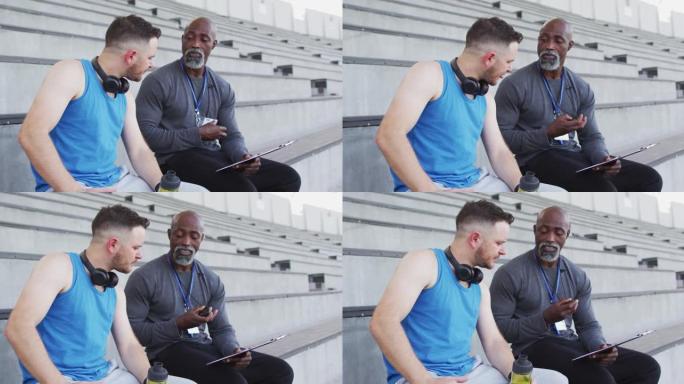 多样化的男教练和运动员在夜间训练中交谈