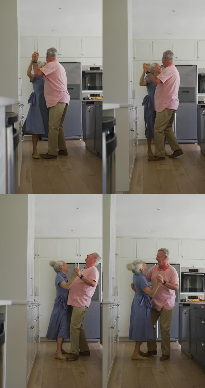 一对白人高级夫妇在厨房跳舞的垂直镜头