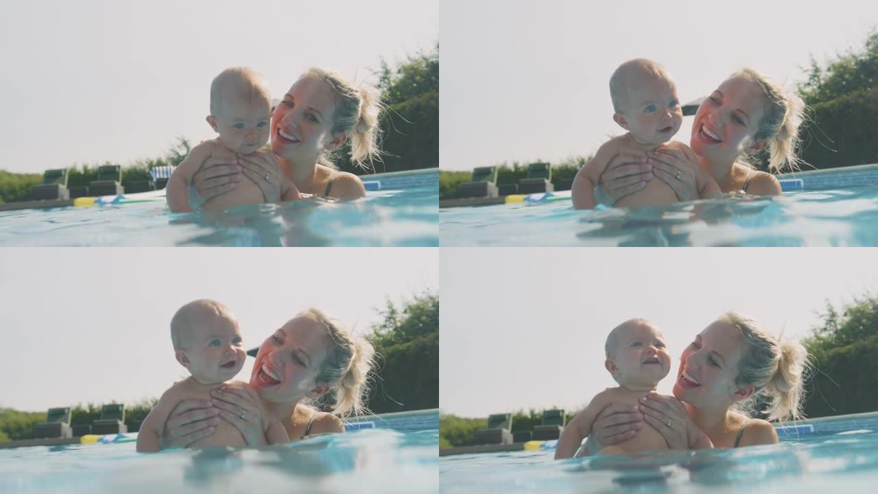 母亲带着小女儿在暑假玩得开心，在游泳池里嬉戏
