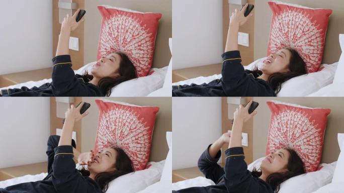 亚洲女子视频与躺在家里床上的朋友在手机上聊天