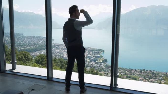 成功的年轻商人在现代大堂房间里，窗户可以俯瞰城市湖全景，思考未来的职业想法