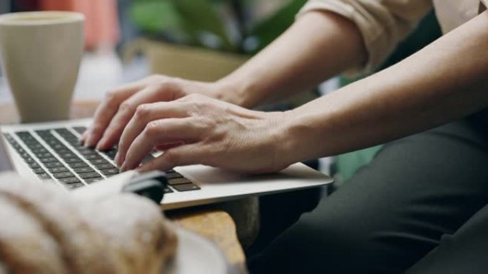 一个无法识别的人在咖啡馆使用笔记本电脑的4k视频片段