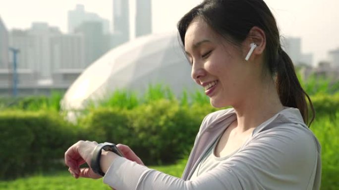 亚洲运动女性在智能手表，可穿戴计算机上检查脉搏