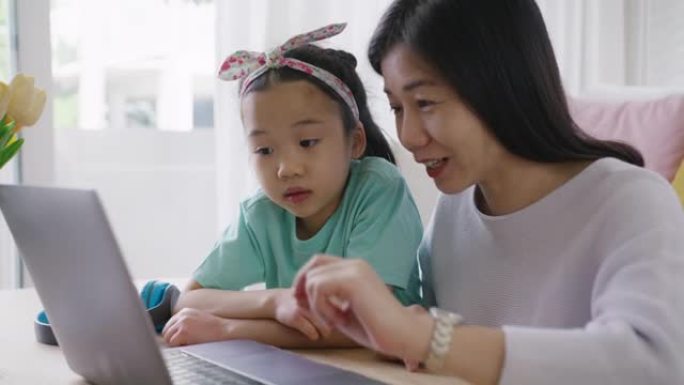 聪明的小孩和妈妈在舒适的房子玩和学习在线课程。