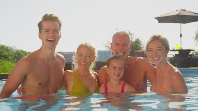 暑假在游泳池放松的微笑多代家庭肖像