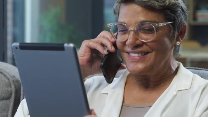 4k视频片段，一名高级妇女在家中使用数字平板电脑时在手机上聊天