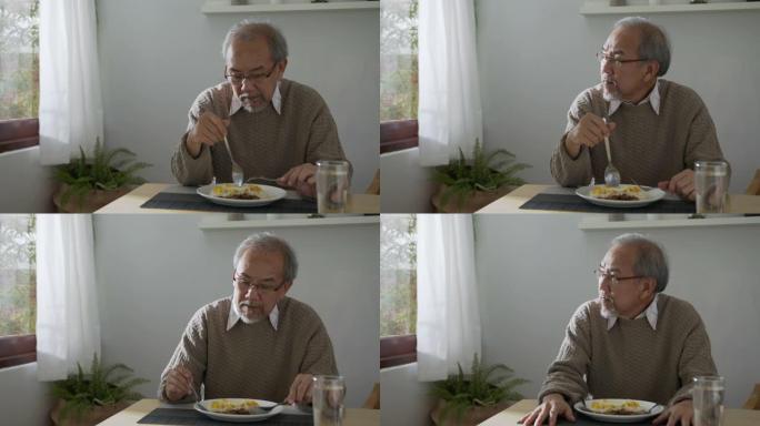 中镜头:悲伤的老退休灰白头发的爷爷亚洲人独自坐在桌子桌子在窗口无聊呆在家里自我隔离感觉抑郁的问题心理