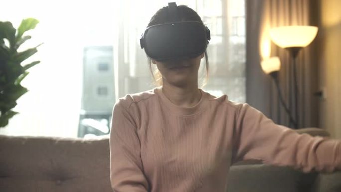 亚洲女性在家使用VR耳机玩游戏
