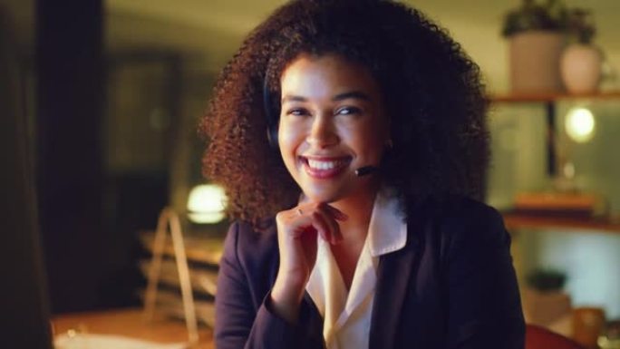 一位年轻的女性呼叫中心代理在办公室工作到很晚时与客户咨询的肖像。一名黑人女性服务台工作人员的脸与客户