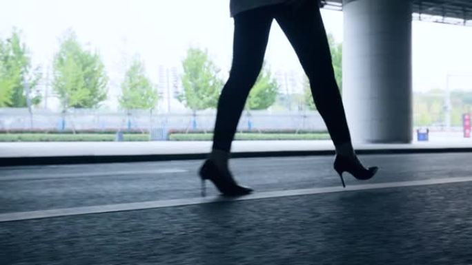 穿着高跟鞋的女性腿走在城市街道上