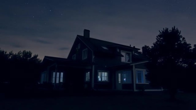 一个大郊区乡间别墅的夜间延时镜头。房地产站在美丽的自然环境中。以旋转的星星和流动的云震撼夜空。
