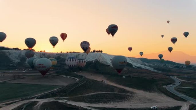 热气球在棉花堡山谷上空升起，对抗山脉和喜怒无常的天空。空中无人机视频