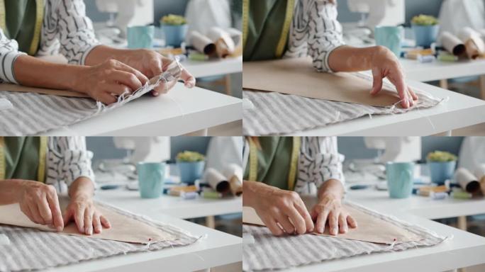 女性在工作室工作时用针缝制衣服的女性手的特写