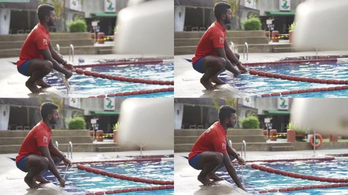亚洲印度救生员在游泳池调节绳索准备