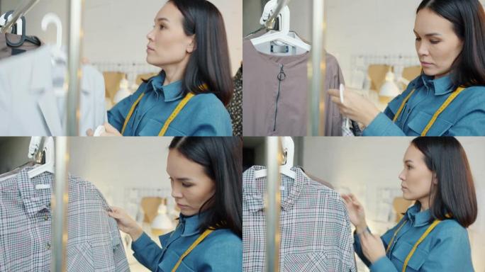 亚洲女性时装设计师在制衣工作室的铁轨上悬挂新衣服