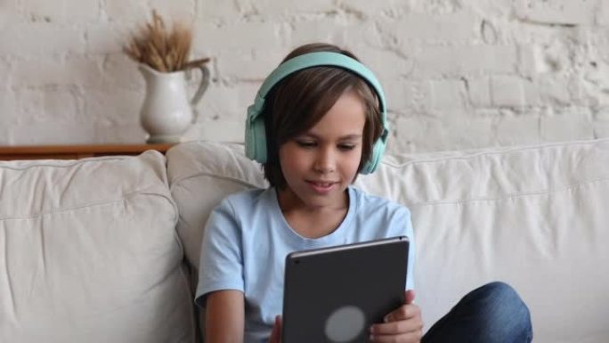 男孩戴耳机使用数字平板电脑开始视频通话对话