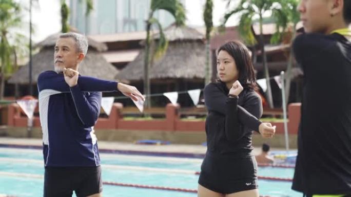 中国女教练教练在去游泳池上游泳课之前进行了热身运动