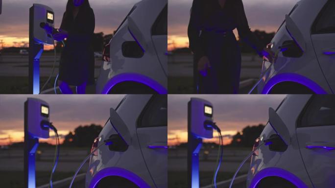 SLO MO女人用蓝色能量在充电站将EV插头插入汽车