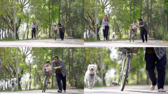 亚洲小男孩喜欢在父母的支持下学习在公园骑自行车。