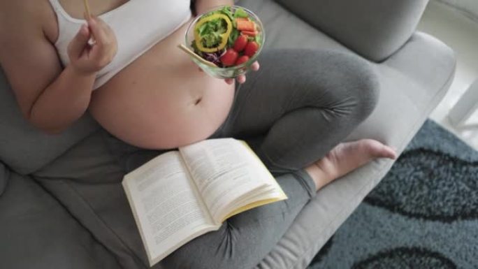 孕妇吃了一顿简单的早餐，早上在家里的沙发上看书放松