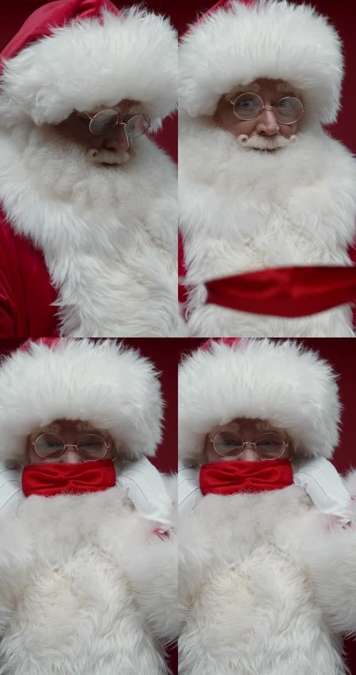红色背景上愉快的圣诞老人的垂直特写，戴上红色防护面罩
