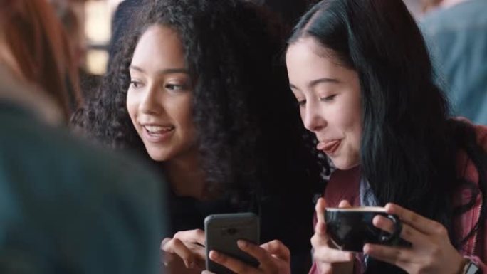 快乐的少女朋友使用智能手机在咖啡馆喝咖啡发短信闲逛分享八卦享受一起聊天