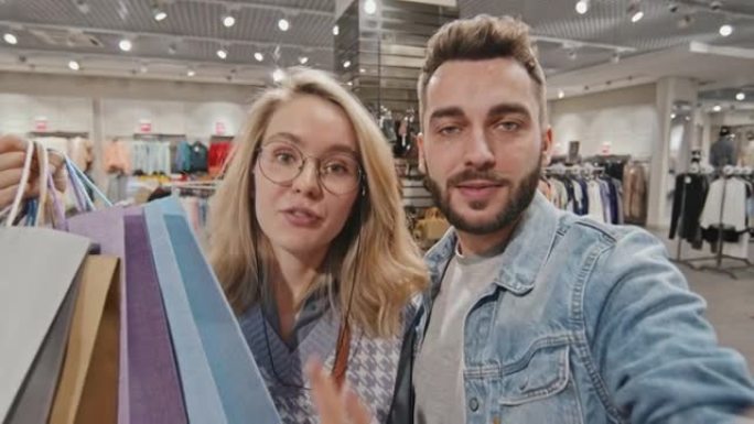 POV快乐年轻夫妇在购物中心视频聊天