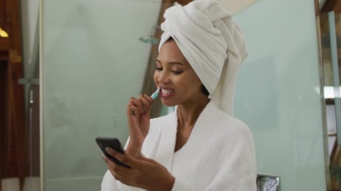混合种族妇女使用智能手机刷牙