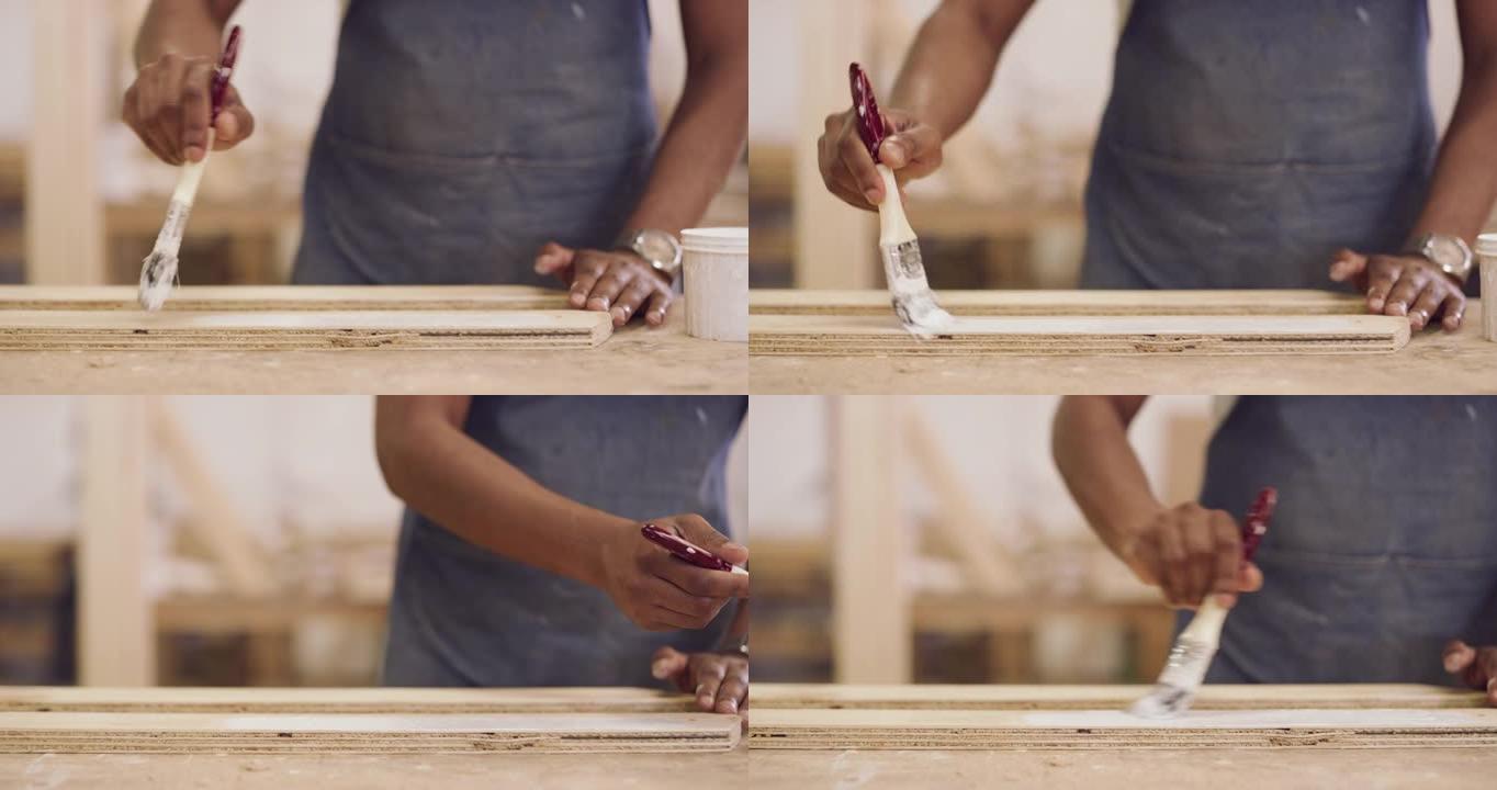 4k视频片段，一名匿名男子在他的木作坊里画了一件作品