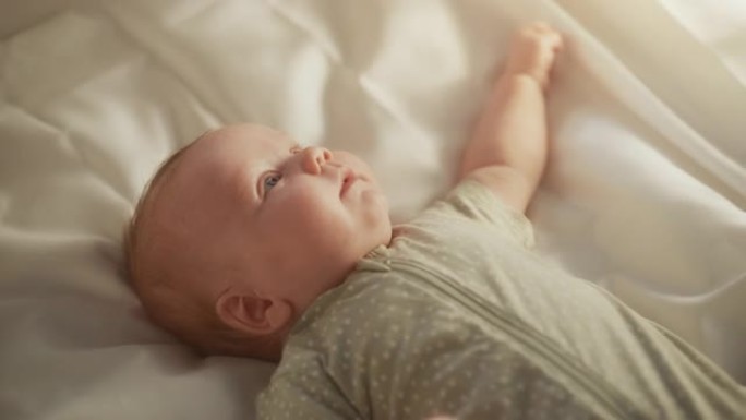 真实的特写镜头，一个可爱的新生婴儿躺在婴儿床的背上。一个高加索新生儿幼儿在舒适的家庭空间的俏皮肖像。