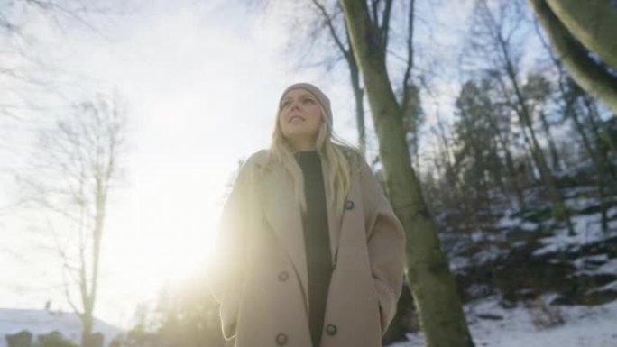 女人在公园里穿过第一场雪