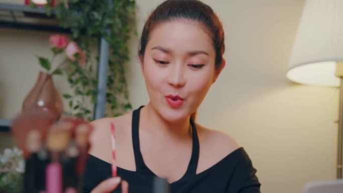 特写亚洲女性youtube影响者教学如何使用哑光液体口红在线教程在家。