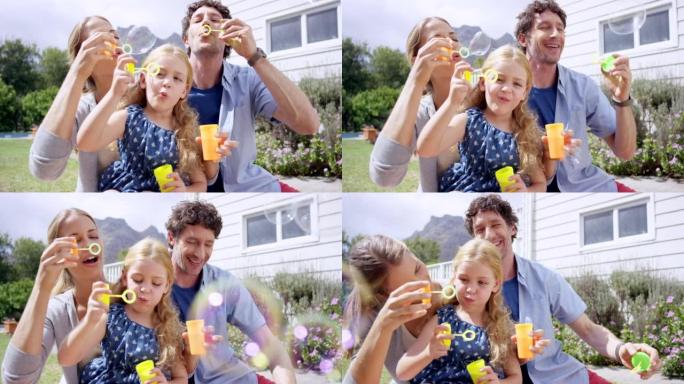 一个小女孩和她的父母一起在户外吹泡泡的4k视频片段