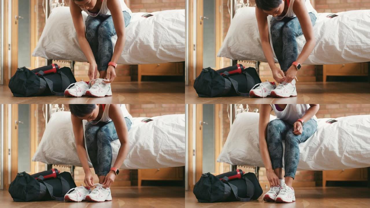 4k视频片段，一名妇女在家中系鞋带以准备锻炼