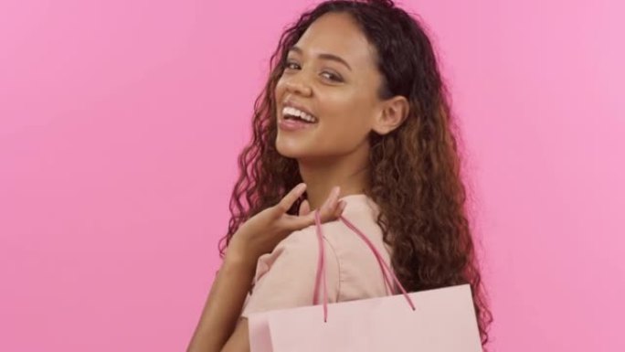 美丽的混血女人在工作室里背着购物袋。混血女性零售疗法购物