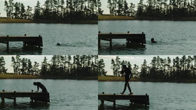 男子在湖中游泳泳衣上岸泳帽