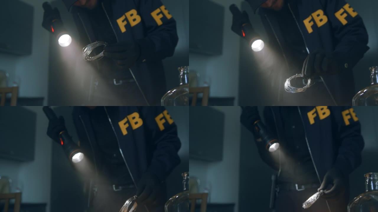 特写一个拿着手电筒的FBI探员在一个黑暗的房间里，手里戴着手套，手里拿着一根电线