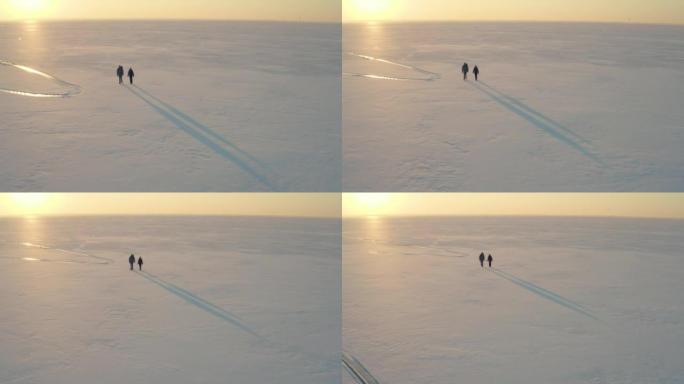 男人和女人走过冰冷的雪原
