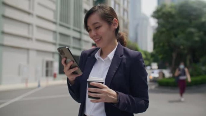 城市中的女商人并使用智能手机
