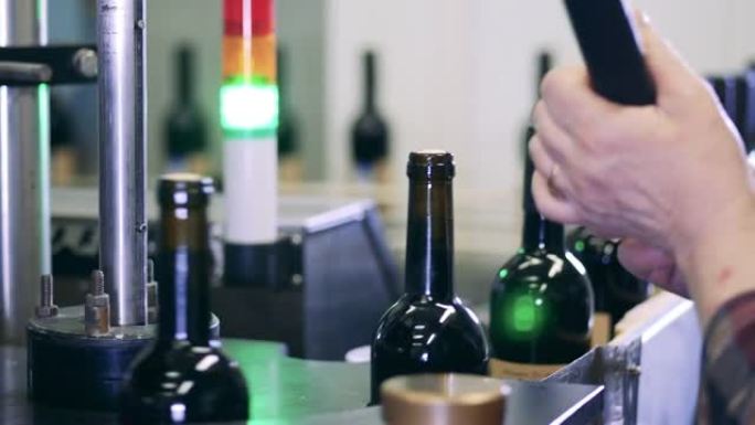 工人在工厂将瓶盖安装在葡萄酒上