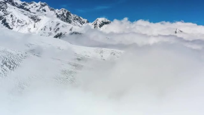 雪山矗立在云海上穿过云雾雪景白皑皑的一片