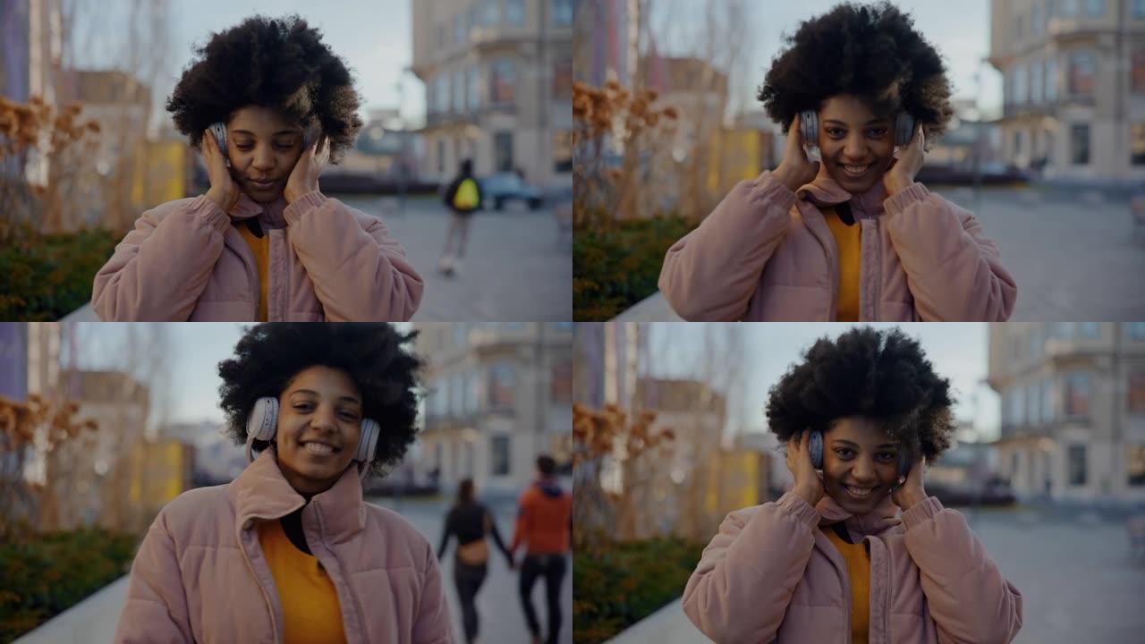 MS肖像拍摄了一个快乐的年轻黑人妇女通过无线耳机听音乐的照片