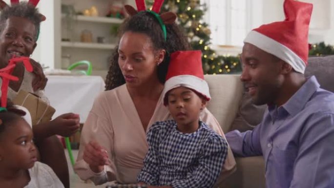 多代家庭在家中戴着圣诞老人帽子和鹿角庆祝圣诞节