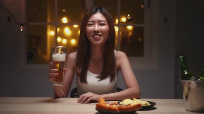 亚洲妇女星期五晚上在视频聊天中喝啤酒参加聚会